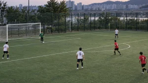 생활축구 경기에서 골키퍼와 수비수들이 골킥 전 세 개의 패스 길을 준비하는 편집 이미지